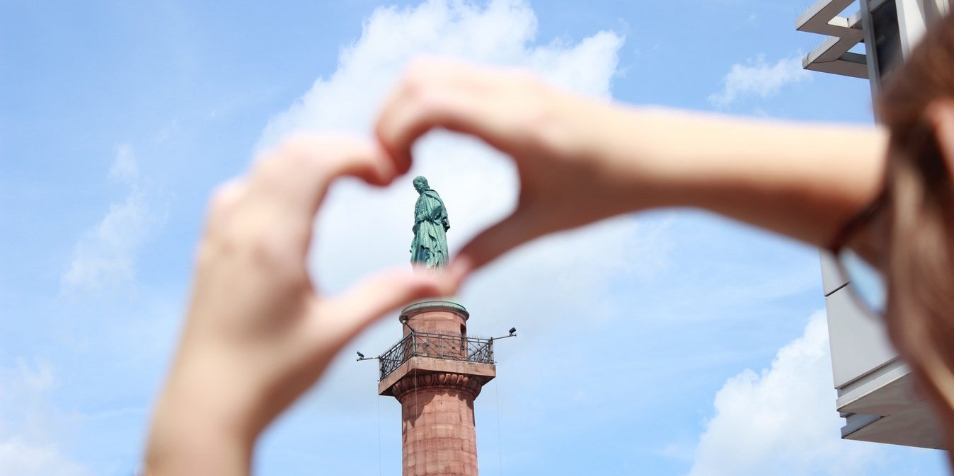 Hände formen Herz um Statue auf Luisenplatz